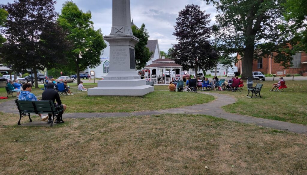 town park concert, people listening to music and enjoying the day